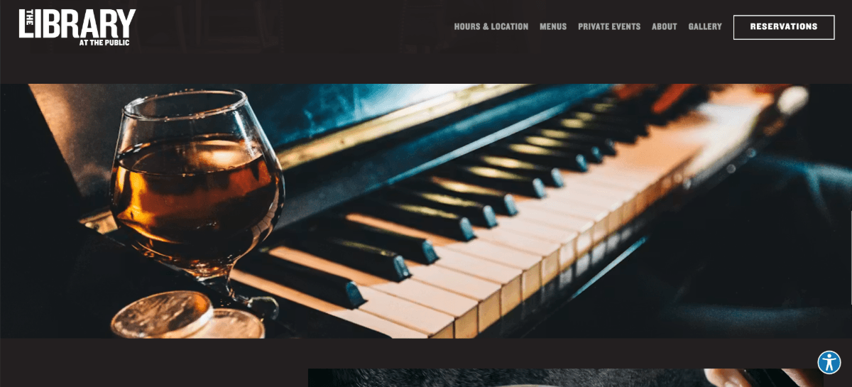 The Library homepage A screenshot from the homepage of the The Library at The Public shows a copy-free section. Wedged between the dark header bar which contains the logo and navigation and the next dark section, there’s a full-screen image of a piano and a glass of dark liquor beside it.