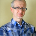 man with blue plaid shirt and glasses